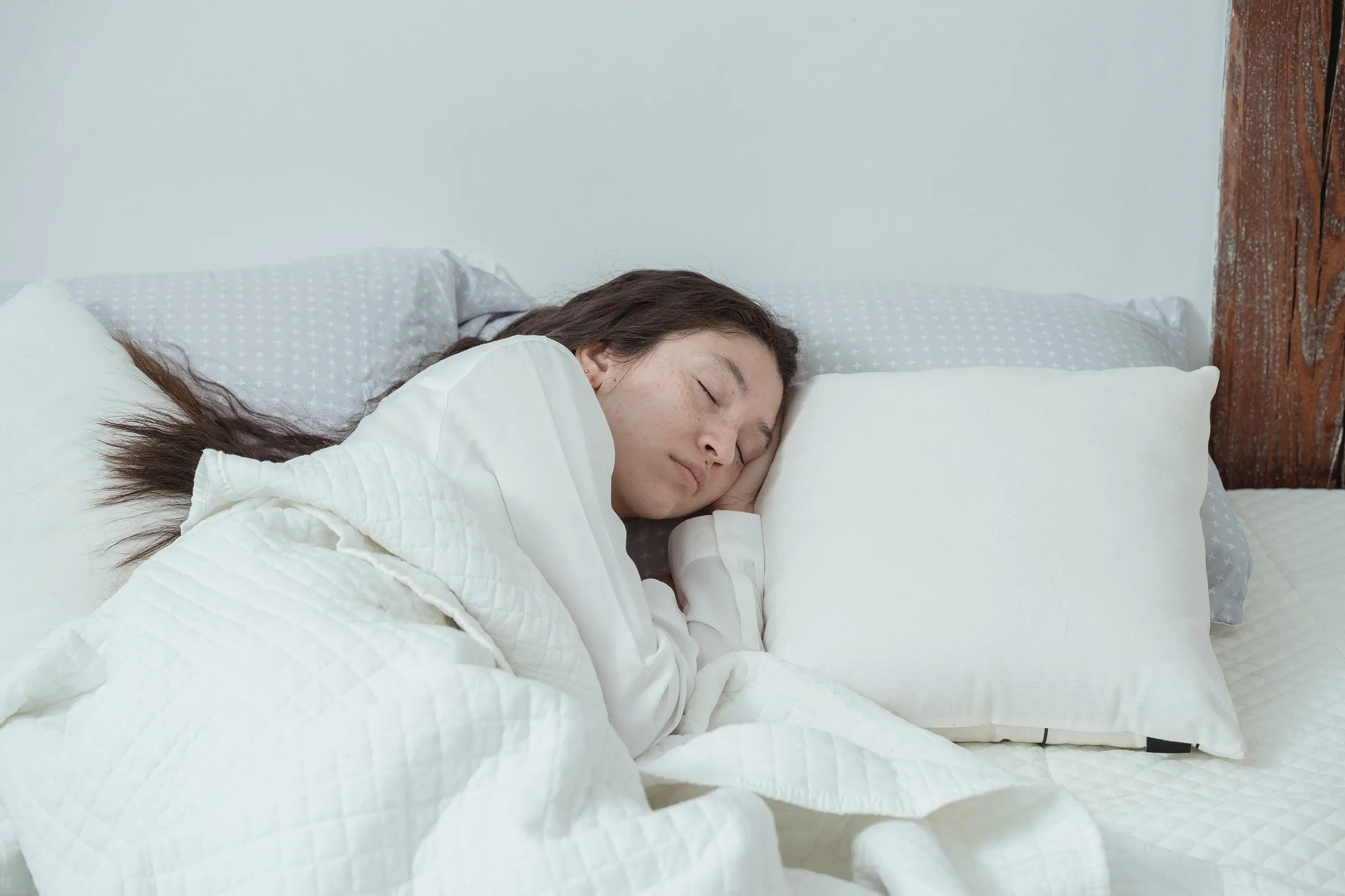 woman sleeping in a white bed